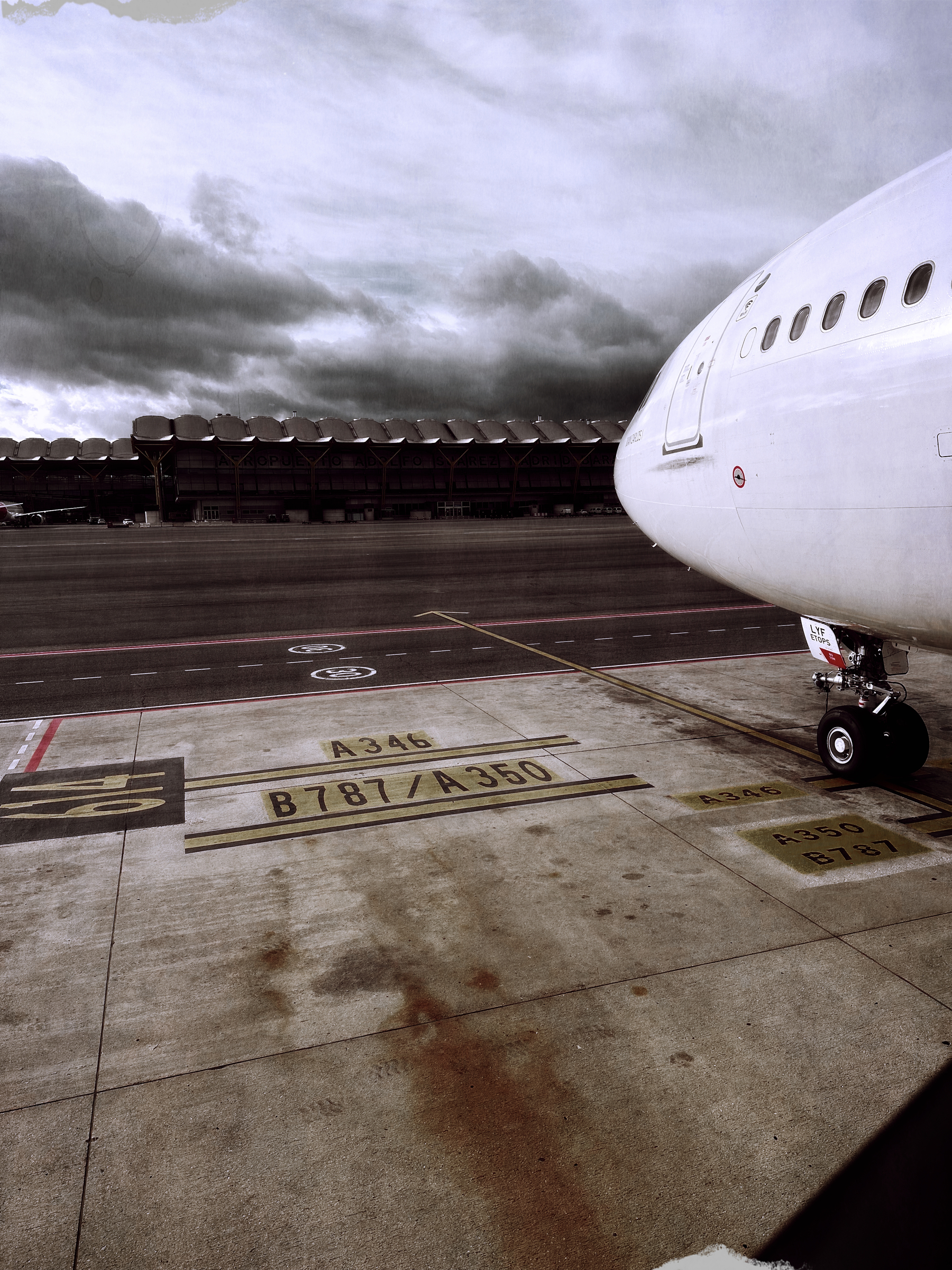 A large aircraft is parked at an airport with a runway marked for different aircraft types.